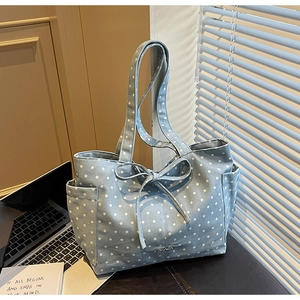 Detailed view of light blue star-print canvas tote bag with side pockets and bow decor