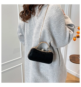 Détail du sac de soirée en velours noir avec poignée dorée et fermoir en cristal