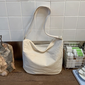 Detail view of cream canvas crossbody bag showing smooth zipper and wide adjustable strap