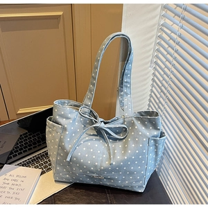 Detail of light blue star pattern canvas tote bag with side pocket and decorative bow knot