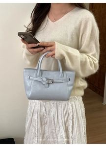 Détail du sac à main en similicuir bleu clair avec boucle et doubles poignées