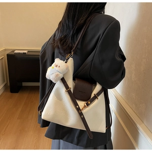 Détail du sac fourre-tout crème avec sangles brunes et pendentif ours en peluche