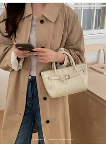 Détail d'un sac à main en cuir blanc crème avec boucle dans un décor de style de vie