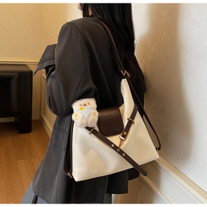 Détail du sac cabas vintage avec rabat contrasté et charmant petit ours en peluche