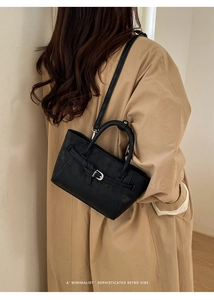 Mini sac à main noir chic doté d'une sangle à boucle sur un modèle en trench-coat classique