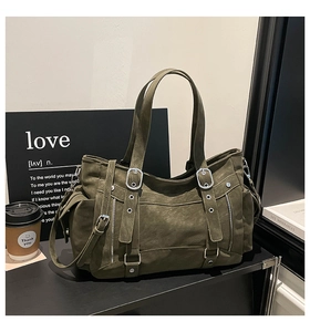 Detail of army green tote bag with matte texture, utility pockets and metallic buckles