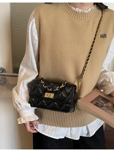 Chic black quilted rhombic pattern chain shoulder bag worn by model in casual style