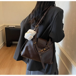 Détail du sac cabas vintage en cuir marron avec garniture dorée et breloque ours