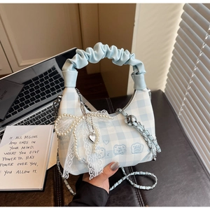 Detail of blue plaid cloud bag with lace pearl bow charm and heart pendant