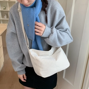 Detail of minimalist canvas crossbody bag with light yellow vertical stripes and wide strap