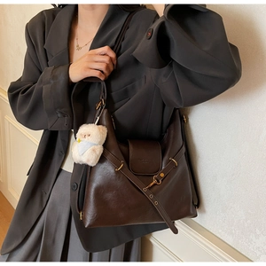Détail du sac cabas vintage marron avec boucle métallique et breloque ours en peluche