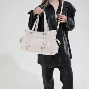 Detail view of large cream tote bag with functional pockets and textured leather