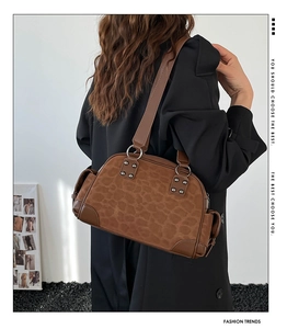 Détail du sac sous le bras à imprimé léopard marron avec clous et poches latérales