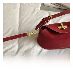 Detailed close-up of premium red leather bag with golden metallic hook and lock buckle