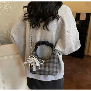 Checkered crossbody bag detail with pearl lace bow charm and silver chain strap