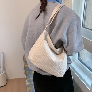 Detail view of cream waffle texture fabric on a large hobo style shoulder bag