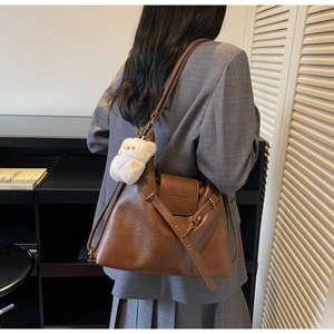 Détail du grand sac cabas en cuir marron vintage avec un adorable pendentif ours