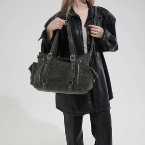 Detail shot of vintage olive green tote bag with multiple zippers on black leather outfit