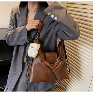 Détail du sac cabas vintage en cuir marron avec breloque ours blanc et boucle