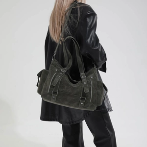 Detail view of olive green retro tote bag with functional zippers and biker style buckles