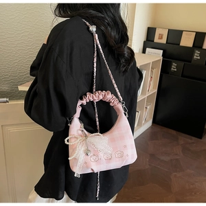 Detail of pink plaid crossbody bag with pleated handle and cute bear paw embroidery