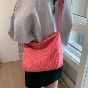 Detailed back view of a red checkered crossbody bag with adjustable canvas shoulder strap