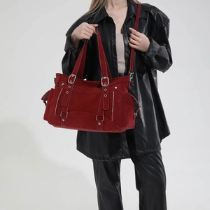 Detail of dark red retro motorcycle tote bag with silver buckles and multi-pocket texture