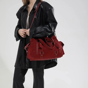 Macro shot of dark red suede tote bag detailing silver buckles and side zippers