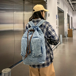 Close-up of blue washed denim backpack with drawstring closure and vintage texture