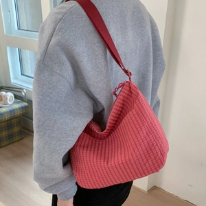 Detailed back view of a large red checkered canvas hobo bag with wide fabric shoulder strap