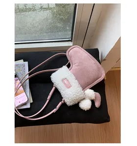 Roze hartvormige crossbodytas met witte rand van imitatielamswol en pompon-bedeltje