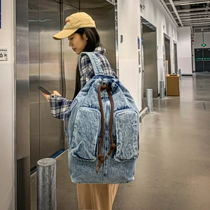 Street style shot of large retro washed denim backpack with double front pockets