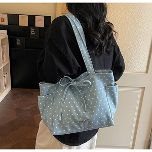 Detail of light blue star print tote bag with bow drawstring and side pockets