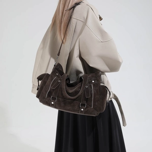 Detail view of large dark brown suede tote bag featuring multi-zipper styling and silver buckles