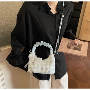 Close-up of blue plaid cloud bag featuring lace bow, pearl decor and metal chain strap