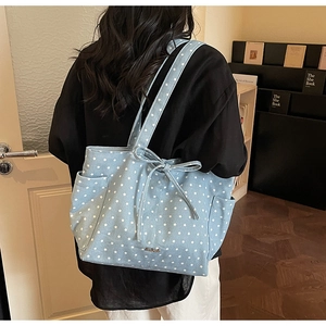 Detail of light blue star print tote bag with bow decoration and side pocket