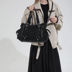 Close-up of black retro tote bag with silver hardware and detailed zipper pockets