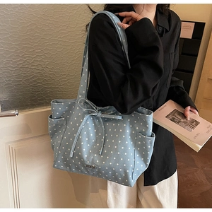 Detail showing blue star pattern tote bag with bow tie decoration and functional side pockets