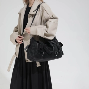 Detail view of black suede tote bag featuring silver buckles and motorcycle style elements