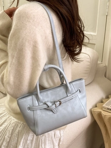 Sac fourre-tout minimaliste en similicuir bleu clair avec bandoulière dans un intérieur douillet