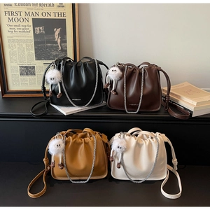 Detail view of stylish pleated bucket bags in black, coffee, caramel and cream leather finishes