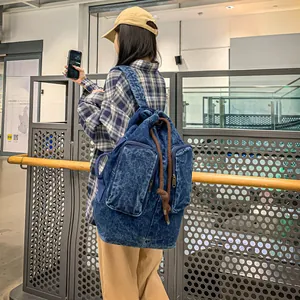 Close-up of vintage blue denim backpack with zipper pockets and drawstring closure