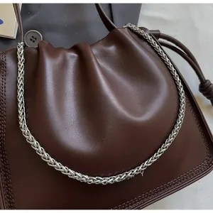 Detail view of the chocolate brown pleated cloud bag with a woven silver metal chain