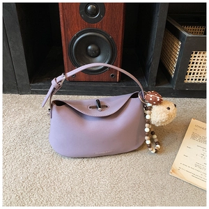 Detail of lavender leather hobo bag featuring metal twist lock and cute plush charm