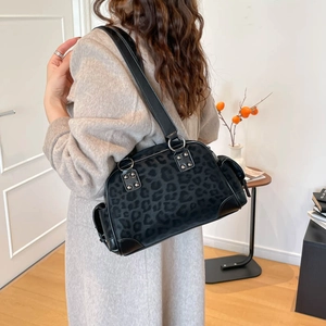 Détails du sac léopard avec rivets argentés et finitions élégantes en cuir noir de haute qualité