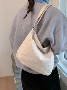 Minimalist cream waffle textured tote bag worn by a model for a casual and stylish look