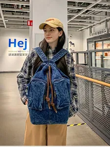 Vintage dark blue washed denim backpack with drawstring closure and large front pockets
