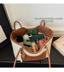 Interior storage of large cream and brown leather tote bag with various daily essentials