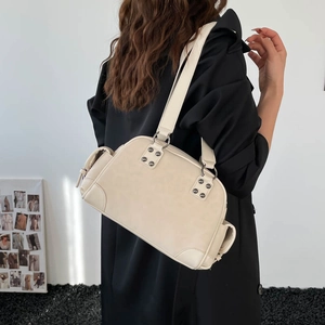 Vue mannequin montrant le profil arrière et la coupe du sac à bandoulière crème clouté