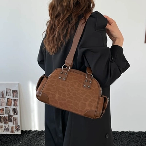 Gros plan détaillé sur la texture léopard marron foncé et les clous argentés du sac